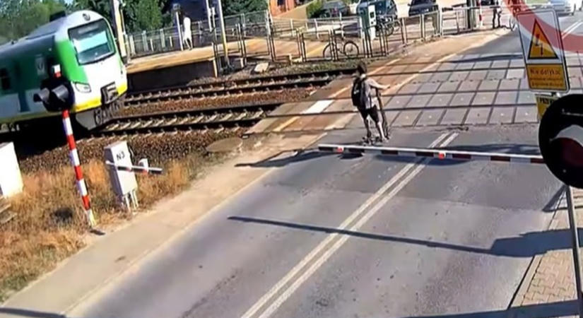 Videón, ahogy centiken múlt a rolleres élete a vasúti átjáróban
