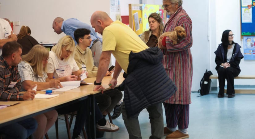 Fürdőköpenyben, kutyával a karjában ment szavazni