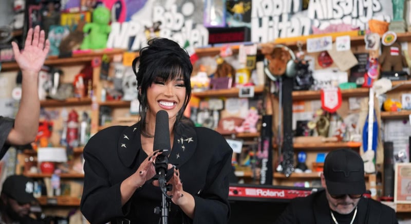 Cardi B egy íróasztal mellett énekelt élő zenekarral